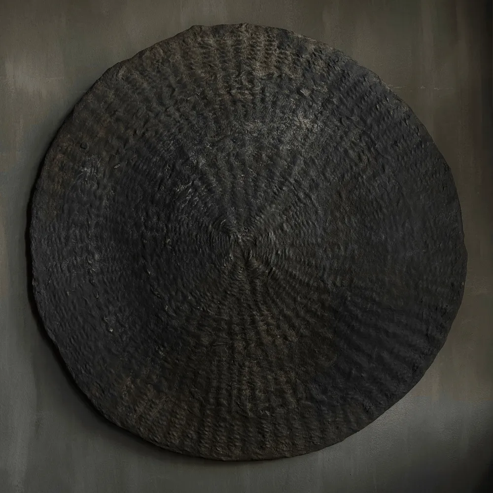 Handgemaakte ronde wanddecoratie in een sobere en landelijke stijl.